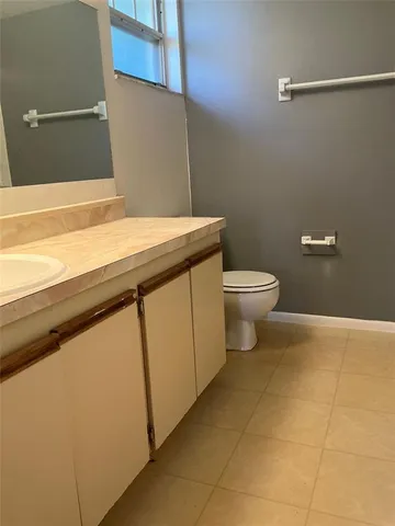 a bathroom with a granite countertop toilet and a sink