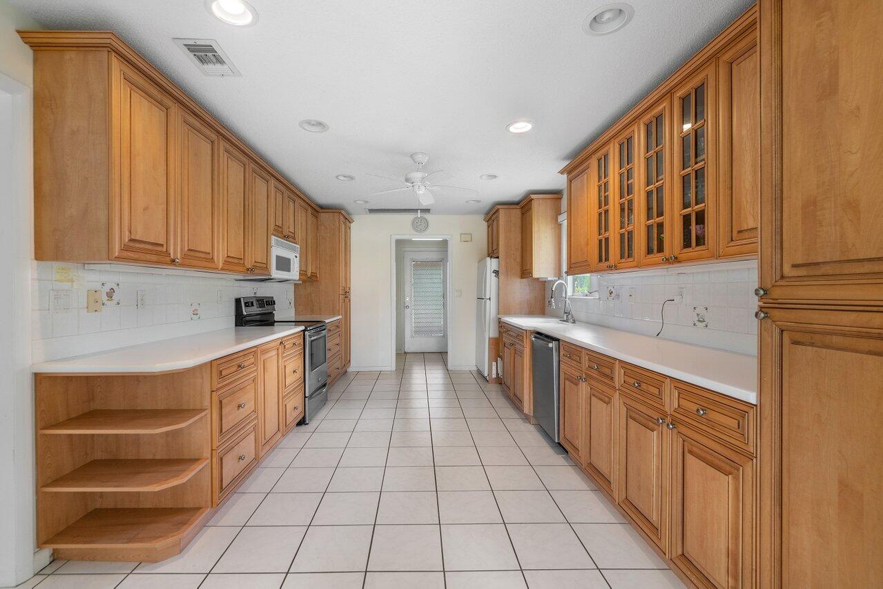 4022 Shell Drake Lane, Unit SHELLDRAKE Boynton Beach, FL 33436 - Photo 13 of 40 a large kitchen with stainless steel appliances granite countertop a sink and cabinets