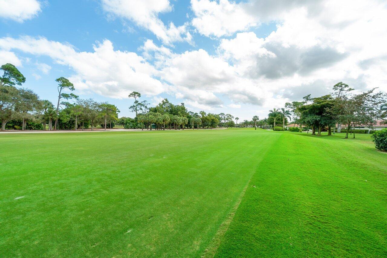 4022 Shell Drake Lane, Unit SHELLDRAKE Boynton Beach, FL 33436 - Photo 30 of 40 a view of a green field with wooden fence