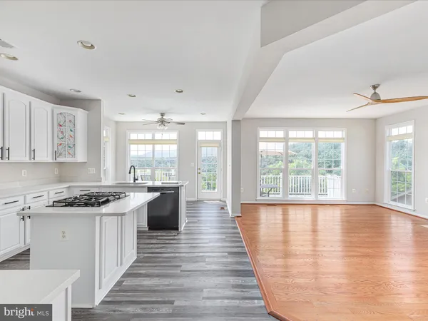 a kitchen with a stove a sink and wooden floor