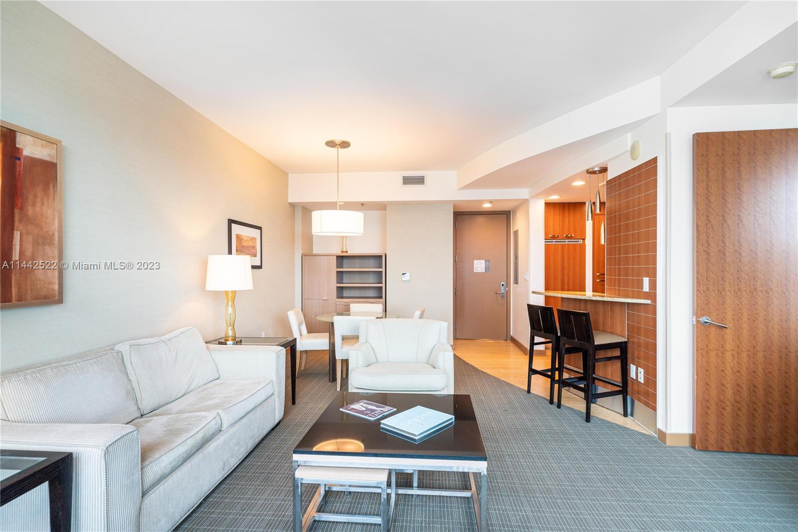 1395 Brickell Avenue, Unit 3205 Miami, FL 33131 - Photo 11 of 18 a living room with furniture a dining table and chairs with wooden floor