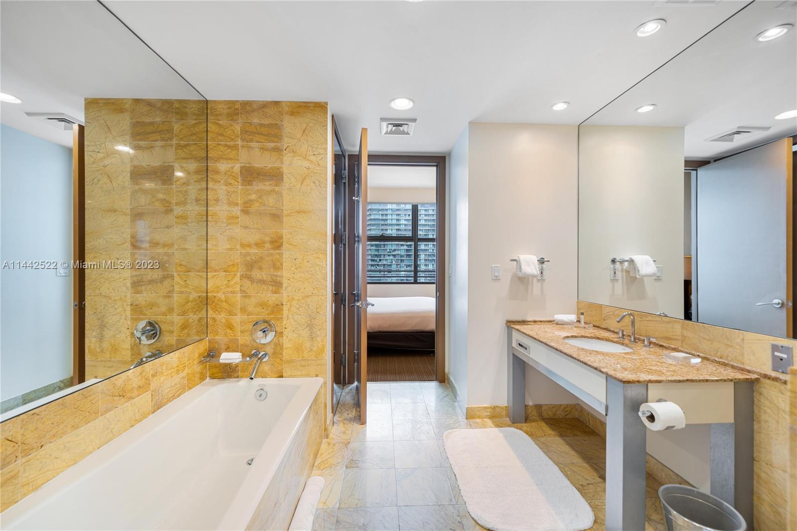 1395 Brickell Avenue, Unit 3205 Miami, FL 33131 - Photo 14 of 18 a bathroom with a tub a sink and mirrors