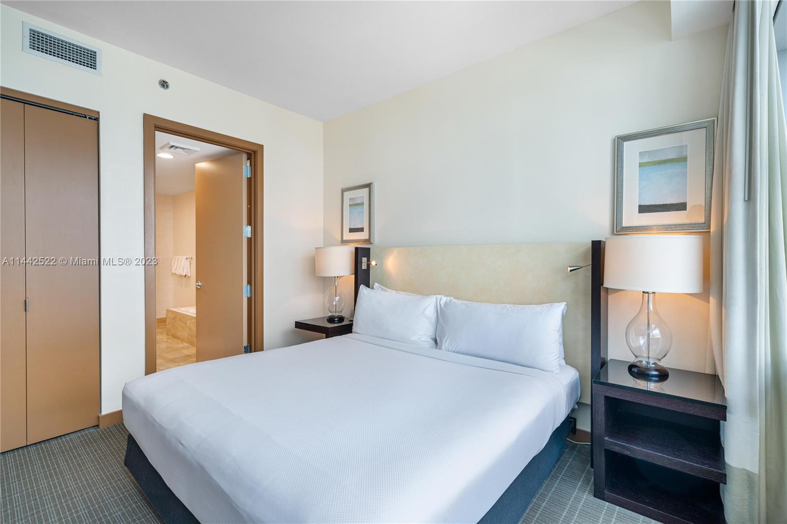 1395 Brickell Avenue, Unit 3205 Miami, FL 33131 - Photo 16 of 18 a bedroom with a bed and wooden floor