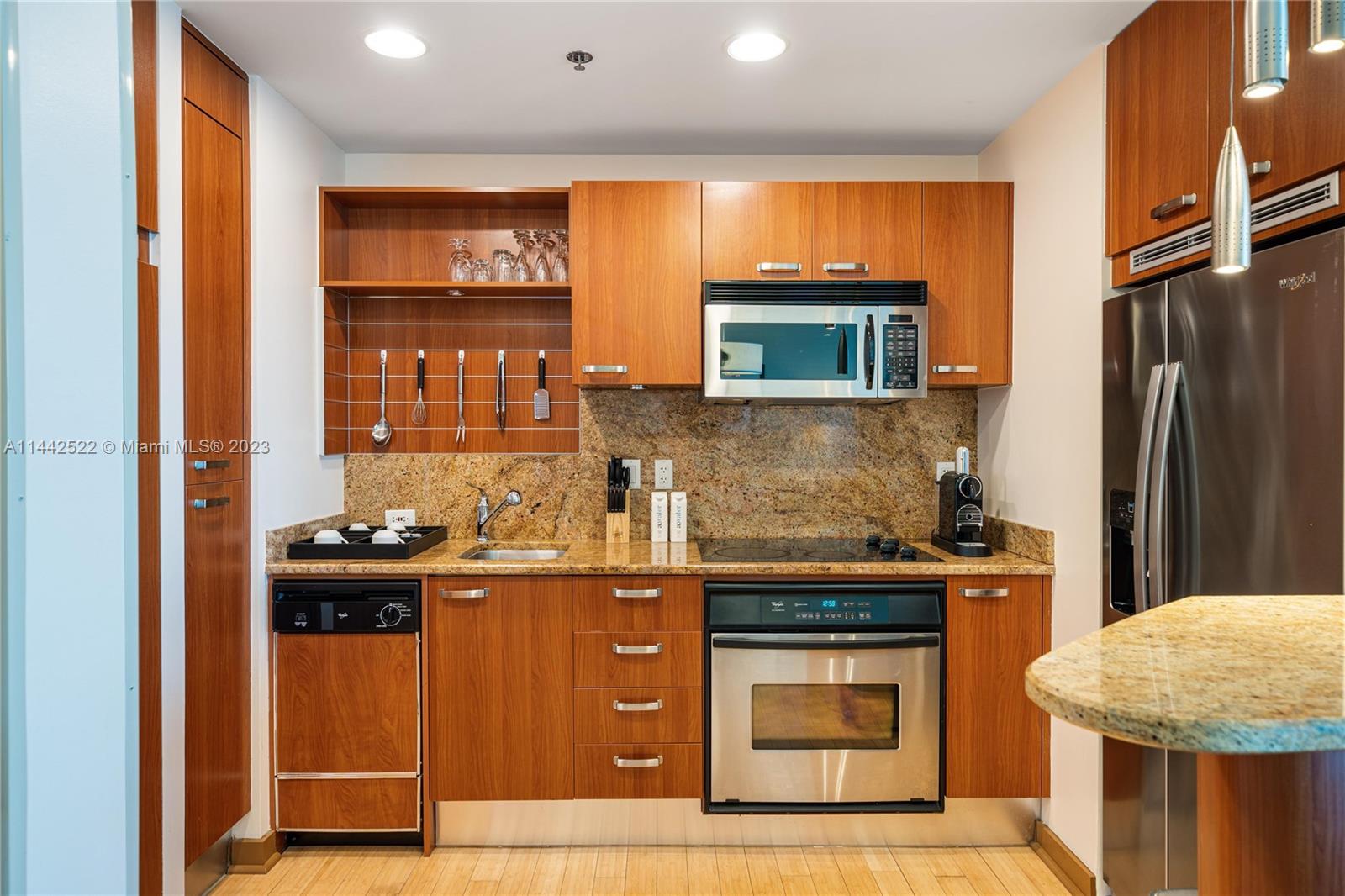 1395 Brickell Avenue, Unit 3205 Miami, FL 33131 - Photo 8 of 18 a kitchen with stainless steel appliances granite countertop a stove and a refrigerator