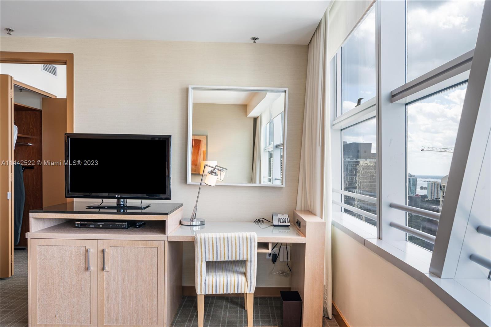 1395 Brickell Avenue, Unit 3205 Miami, FL 33131 - Photo 9 of 18 a living room with dining table and a flat screen tv