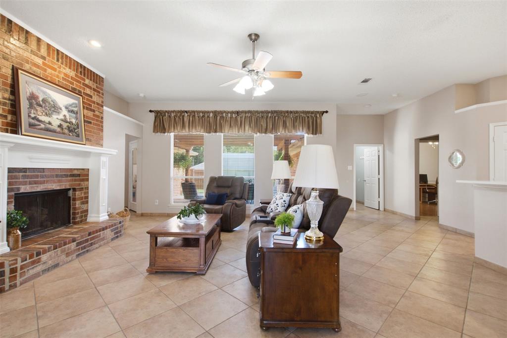 4218 Glistening Spring Rowlett, TX 75088 - Photo 6 of 39 Spacious interior featuring neutral paint, ceramic tile flooring, a brick fireplace with a white mantle, recessed lighting, and a ceiling fan