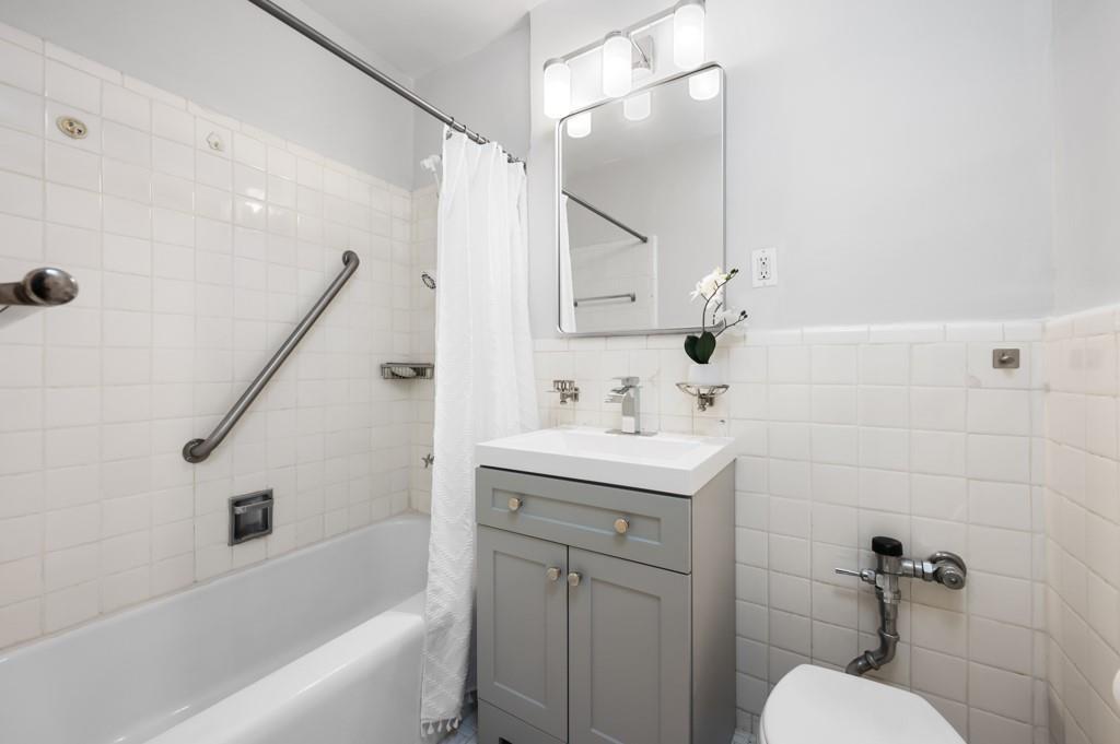 9201 Shore Road, Unit C403 Brooklyn, NY 11209 - Photo 13 of 16 a bathroom with a sink toilet and shower