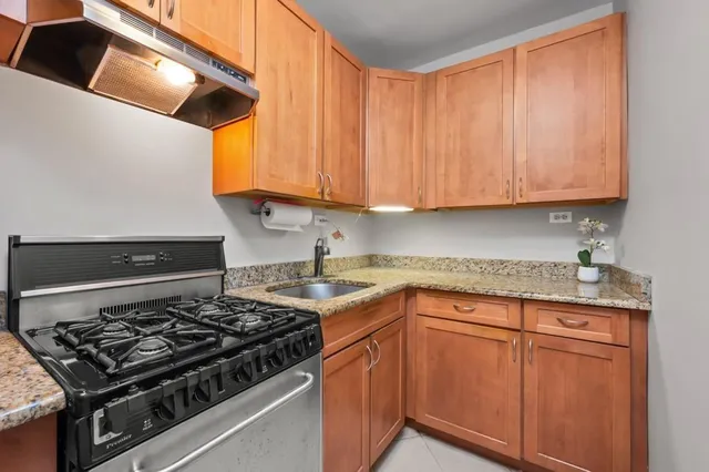 a kitchen with granite countertop a sink stainless steel appliances and cabinets