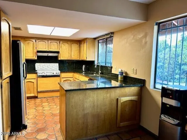 a kitchen with stainless steel appliances granite countertop a sink and a refrigerator