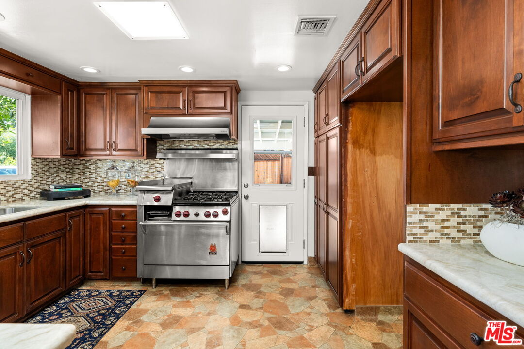 11080 Plainview Avenue Tujunga, CA 91042 - Photo 12 of 41 a kitchen with stainless steel appliances granite countertop a stove a sink and a refrigerator