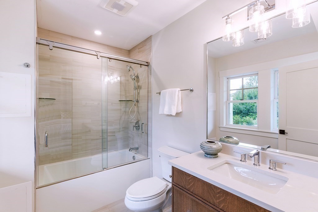 163 Atlantic Road, Unit 8 Gloucester, MA 01930 - Photo 13 of 21 a bathroom with a sink a toilet and a large mirror