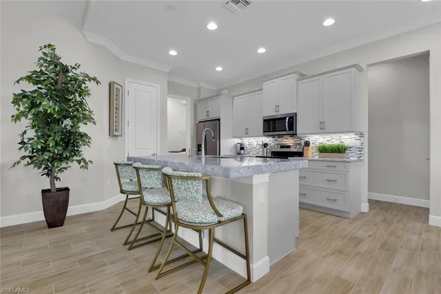 a kitchen with microwave a stove and a wooden floor