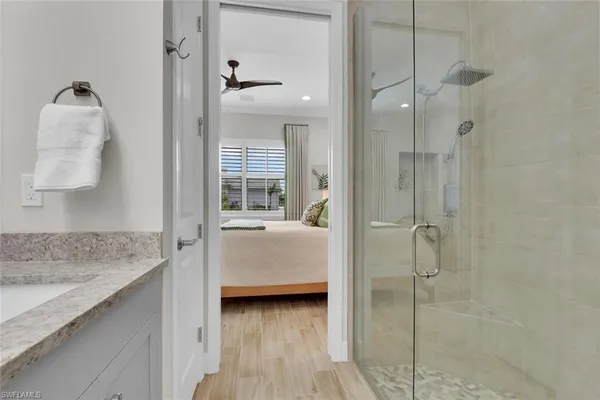 a en suite bathroom with a granite countertop sink and shower