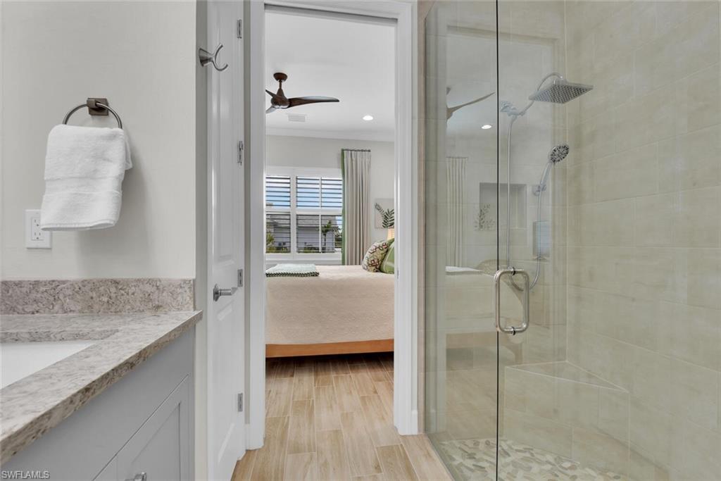 7110 Cayo Coco Lane Naples, FL 34113 - Photo 21 of 45 a en suite bathroom with a granite countertop sink and shower