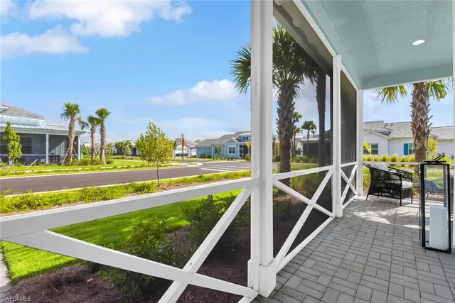 a view of a swimming pool with a lawn chairs and a large tree