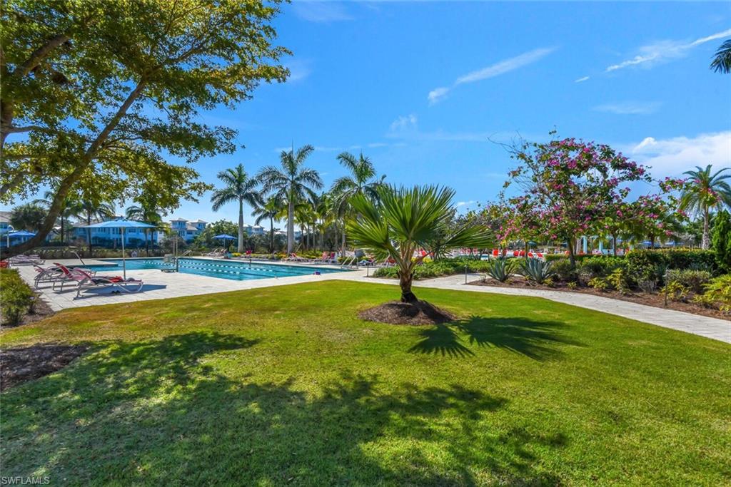 7110 Cayo Coco Lane Naples, FL 34113 - Photo 38 of 45 a view of a swimming pool with a yard and palm trees