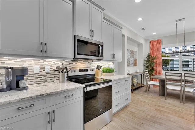 a kitchen with cabinets stainless steel appliances and wooden floor