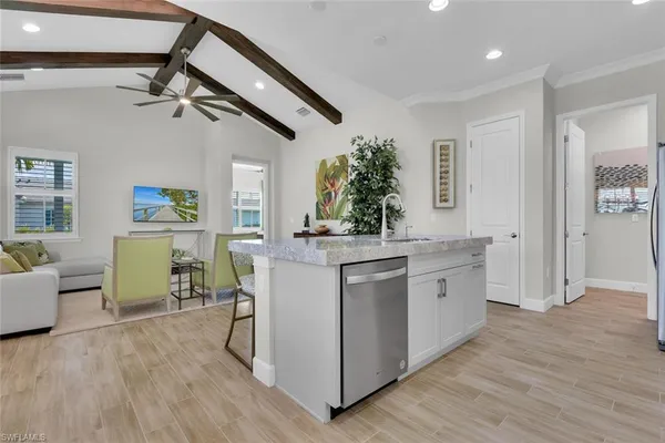 a kitchen with kitchen island white cabinets and wooden floor