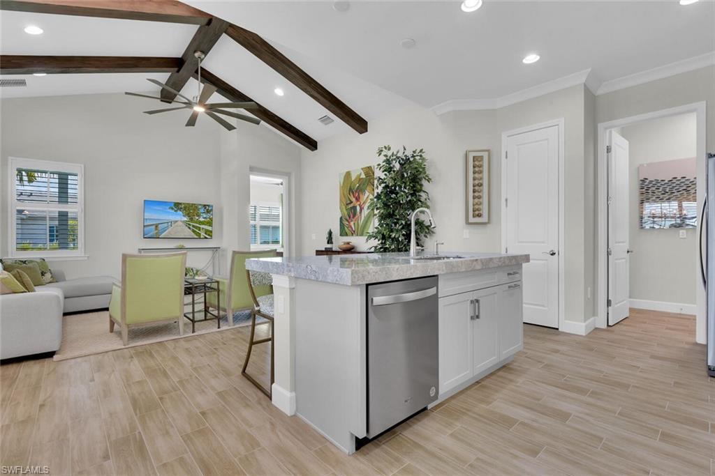 7110 Cayo Coco Lane Naples, FL 34113 - Photo 10 of 45 a kitchen with kitchen island white cabinets and wooden floor
