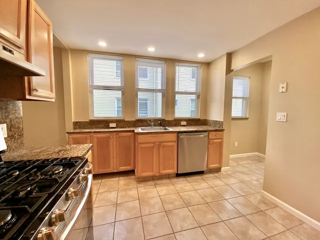 a kitchen with stainless steel appliances granite countertop a stove a sink and a microwave