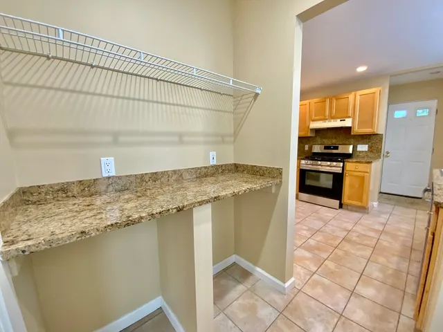 a kitchen with granite countertop a stove a sink and a refrigerator