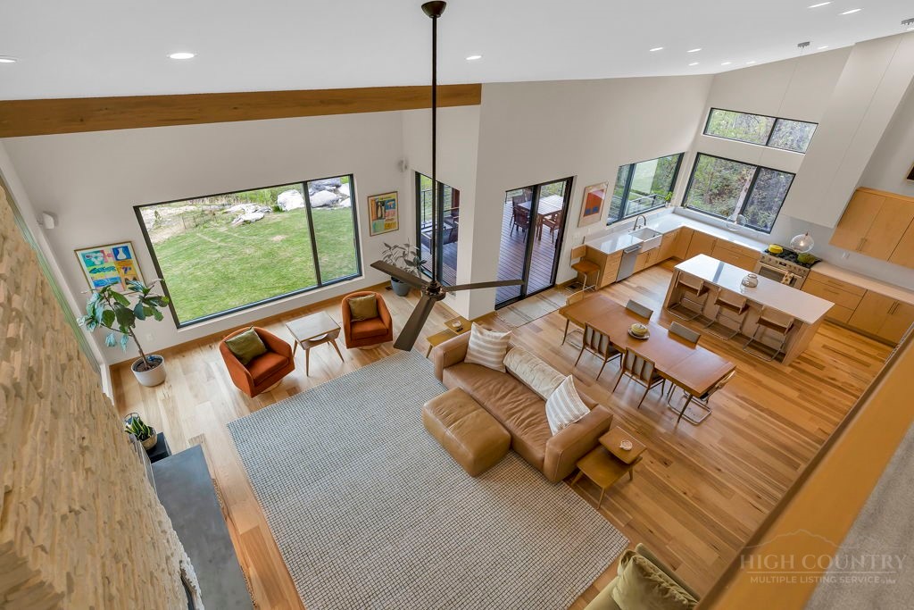799 Milton Brown Heirs Road Boone, NC 28607 - Photo 11 of 49 a living room with furniture floor to ceiling window and a flat screen tv