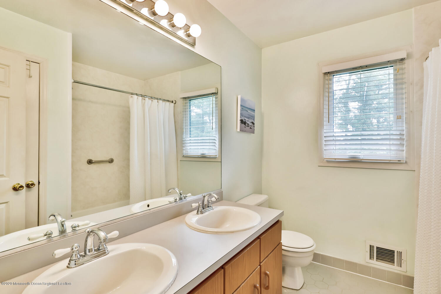 38 Knob Hill Road Morganville, NJ 07751 - Photo 27 of 35 a bathroom with double vanity sinks a toilet a mirror and a window