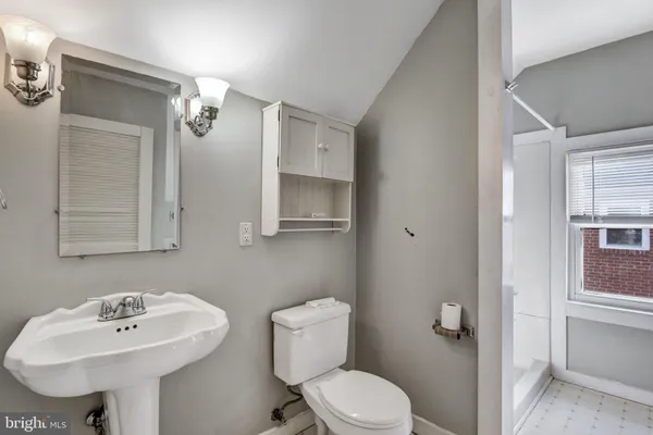 a bathroom with a sink a toilet and mirror