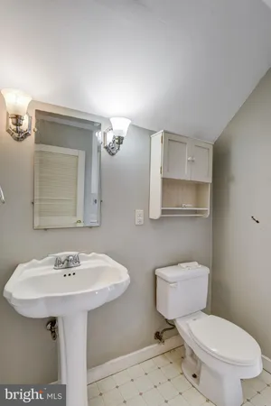 a bathroom with a sink toilet and a mirror
