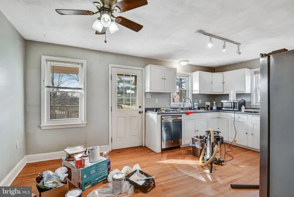 a kitchen with a refrigerator a stove cabinets dining table and chairs