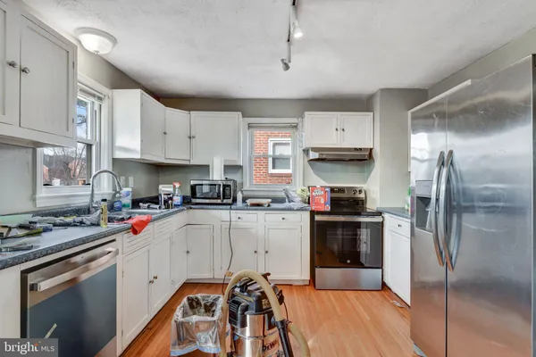 a kitchen with stainless steel appliances a stove refrigerator sink and cabinets