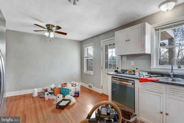a kitchen that has a sink cabinets and wooden floor