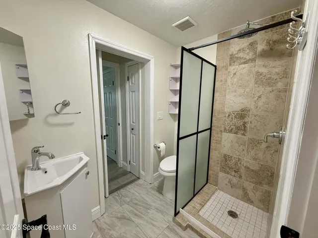 a bathroom with a shower and a sink