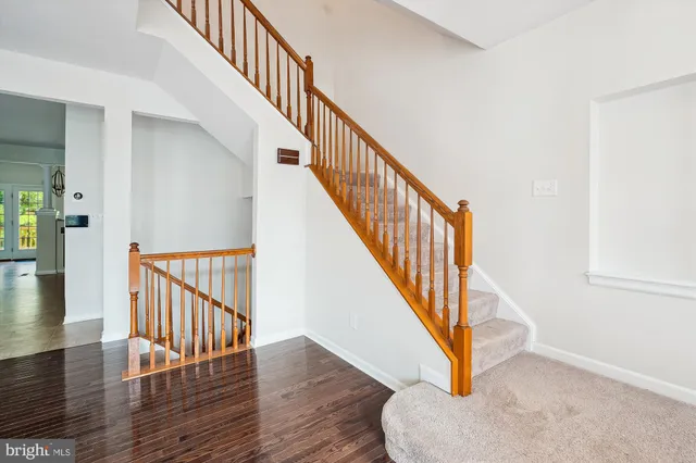 a view of staircase with wooden floor and white walls