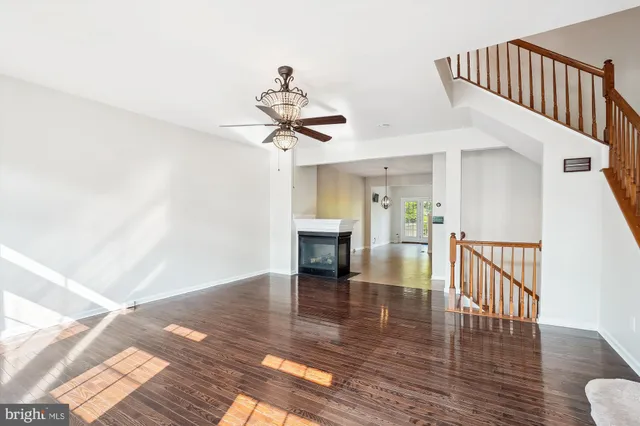 a view of a livingroom with wooden floor and a ceiling fan