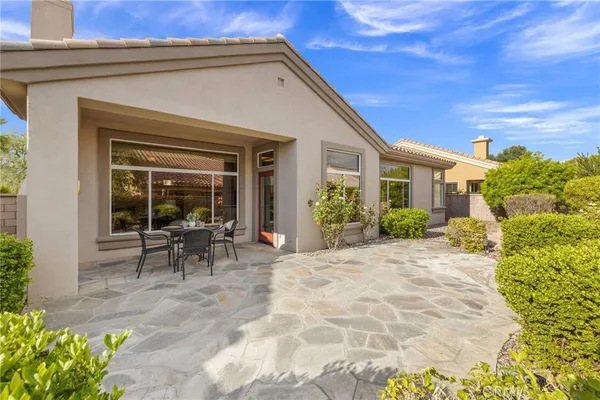 a view of house with backyard and outdoor seating