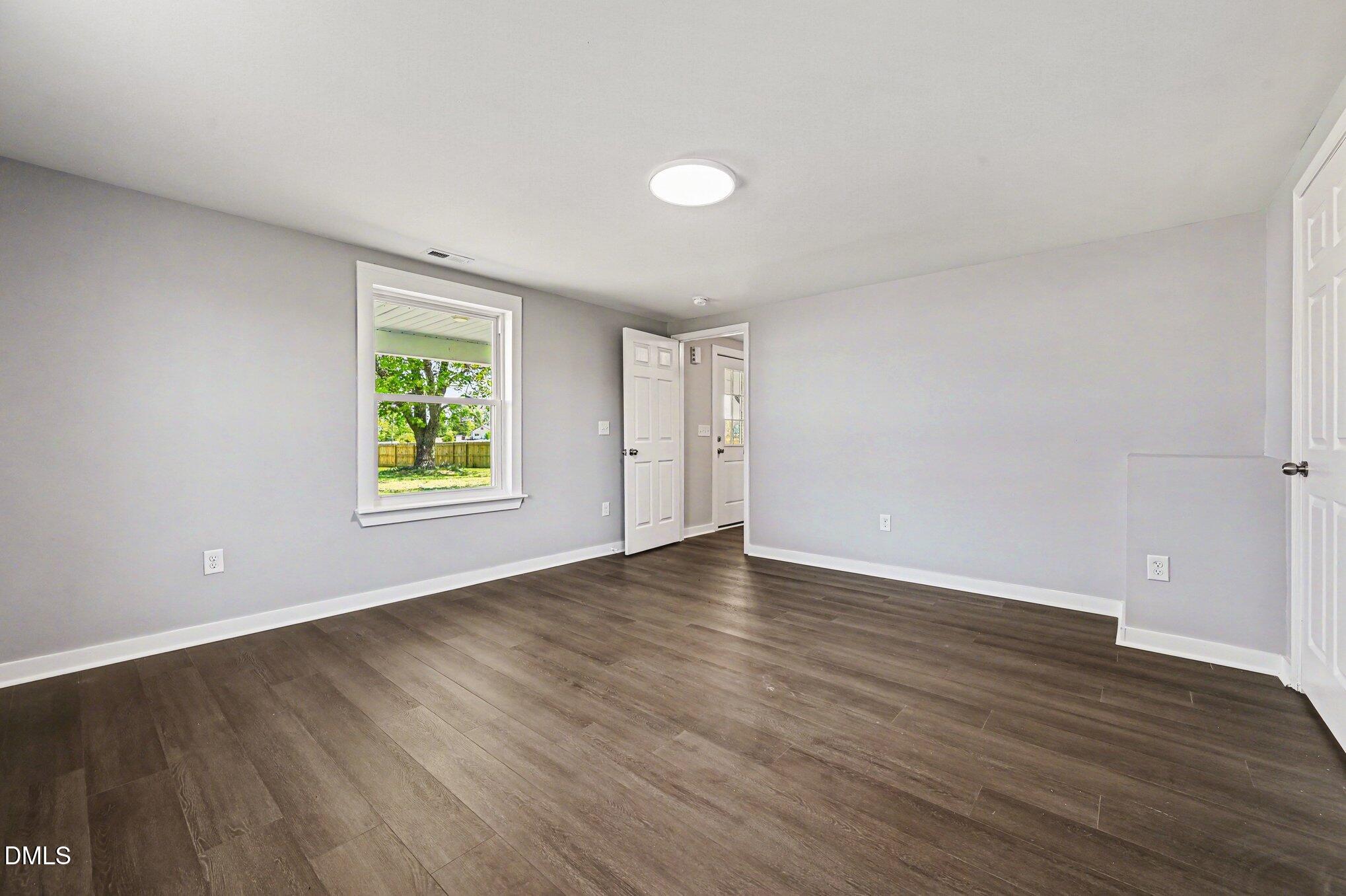 1325 Charlie Carr Road Roxboro, NC 27574 - Photo 23 of 31 an empty room with wooden floor and window