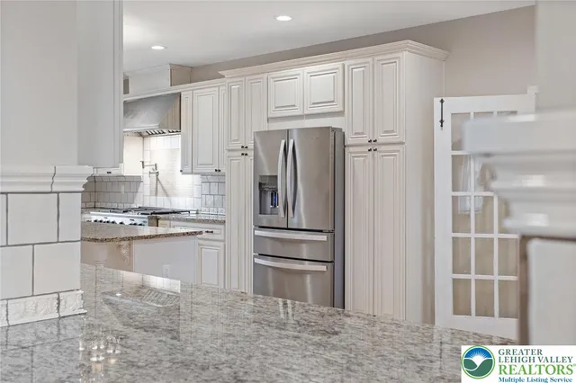 a kitchen with stainless steel appliances granite countertop a refrigerator and a stove top oven