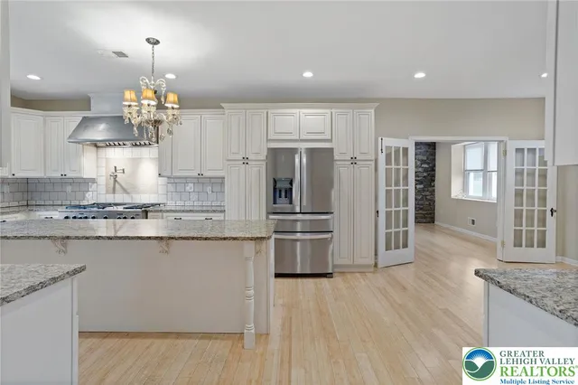 a kitchen with stainless steel appliances granite countertop a stove refrigerator and cabinets