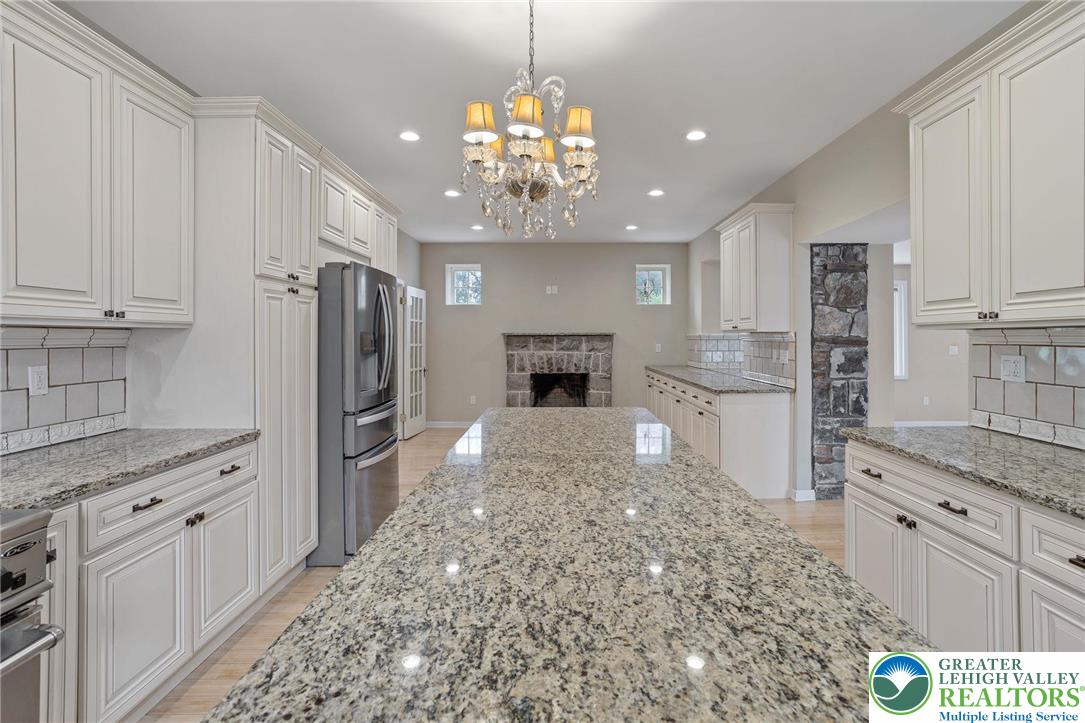 1790 Friedensville Road Bethlehem, PA 18015 - Photo 19 of 50 a kitchen with kitchen island granite countertop a refrigerator oven a sink dishwasher and white cabinets with wooden floor
