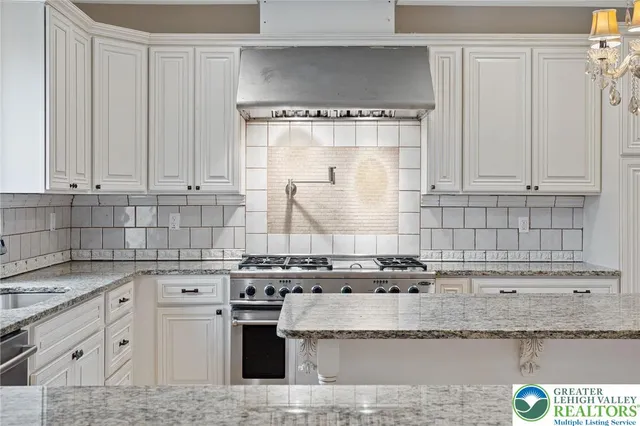 a kitchen with granite countertop a sink stainless steel appliances and cabinets