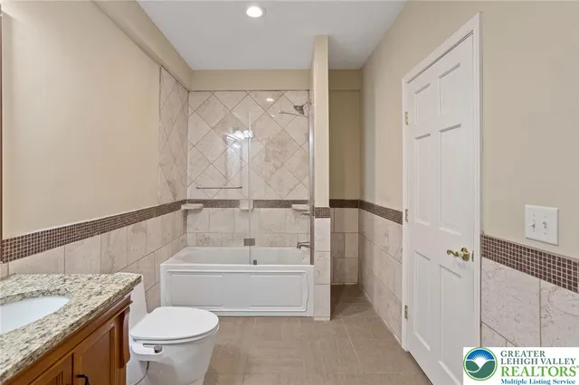 a bathroom with a granite countertop sink toilet and shower