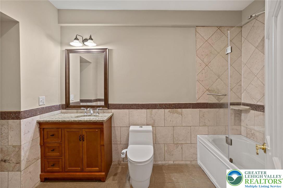 1790 Friedensville Road Bethlehem, PA 18015 - Photo 34 of 50 a bathroom with a granite countertop sink a toilet and a bathtub
