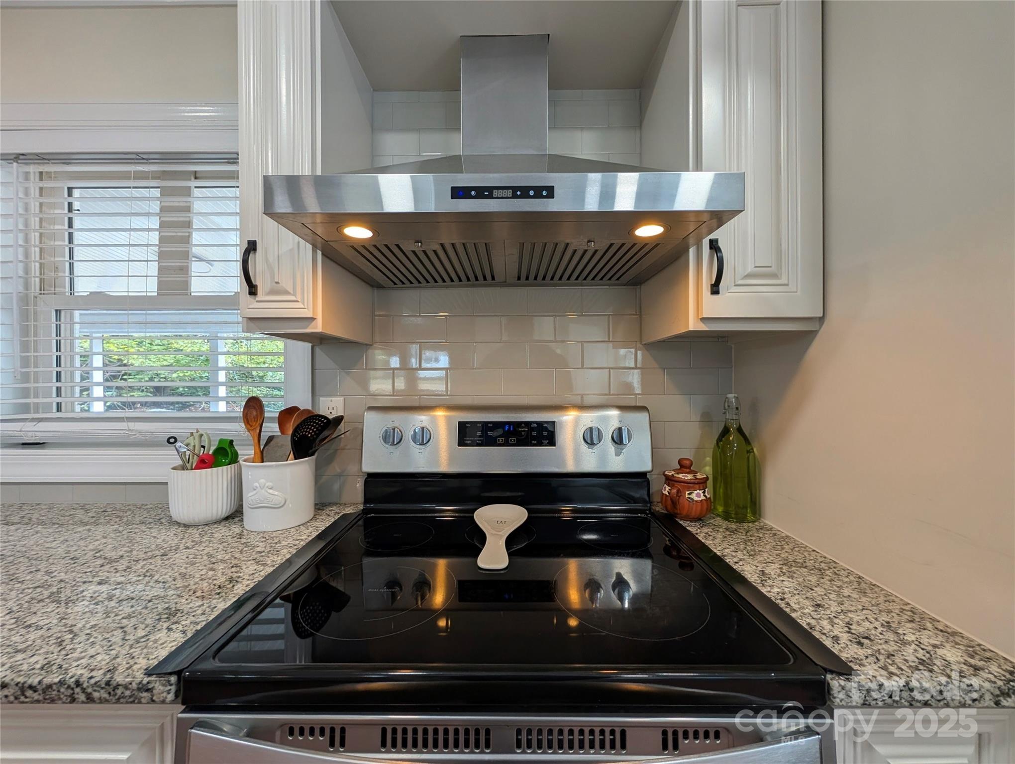 3220 Jonesberry Road Matthews, NC 28105 - Photo 14 of 27 a kitchen with a stove a window cabinets and a counter top space