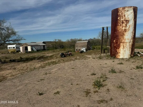 a view of a dry yard with wooden fence