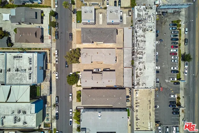 an aerial view of residential houses with outdoor space and parking