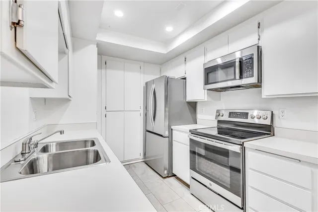 a kitchen with stainless steel appliances granite countertop a refrigerator stove and sink