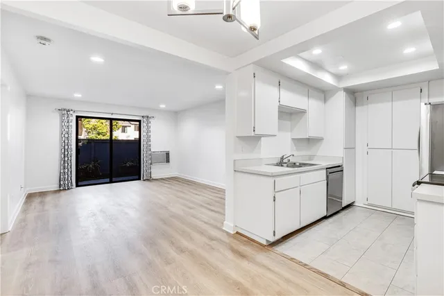 a kitchen with granite countertop white cabinets and white appliances