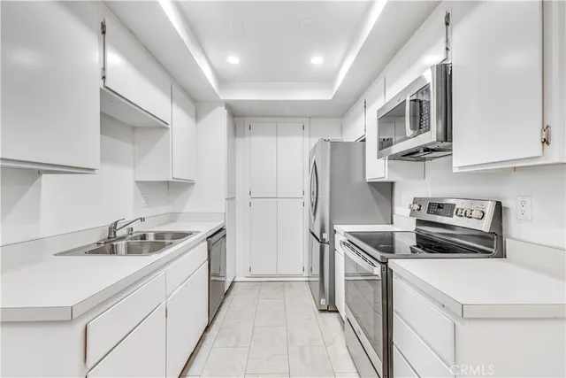 a kitchen with stainless steel appliances a sink stove and refrigerator