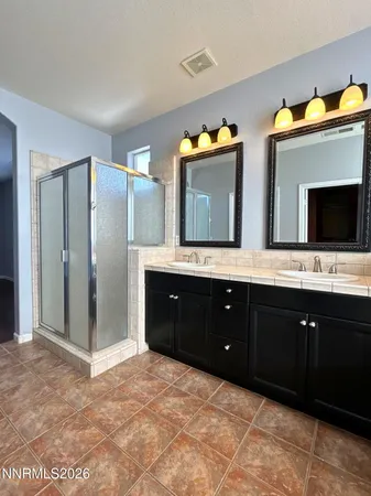 a spacious bathroom with a double vanity sink and a mirror
